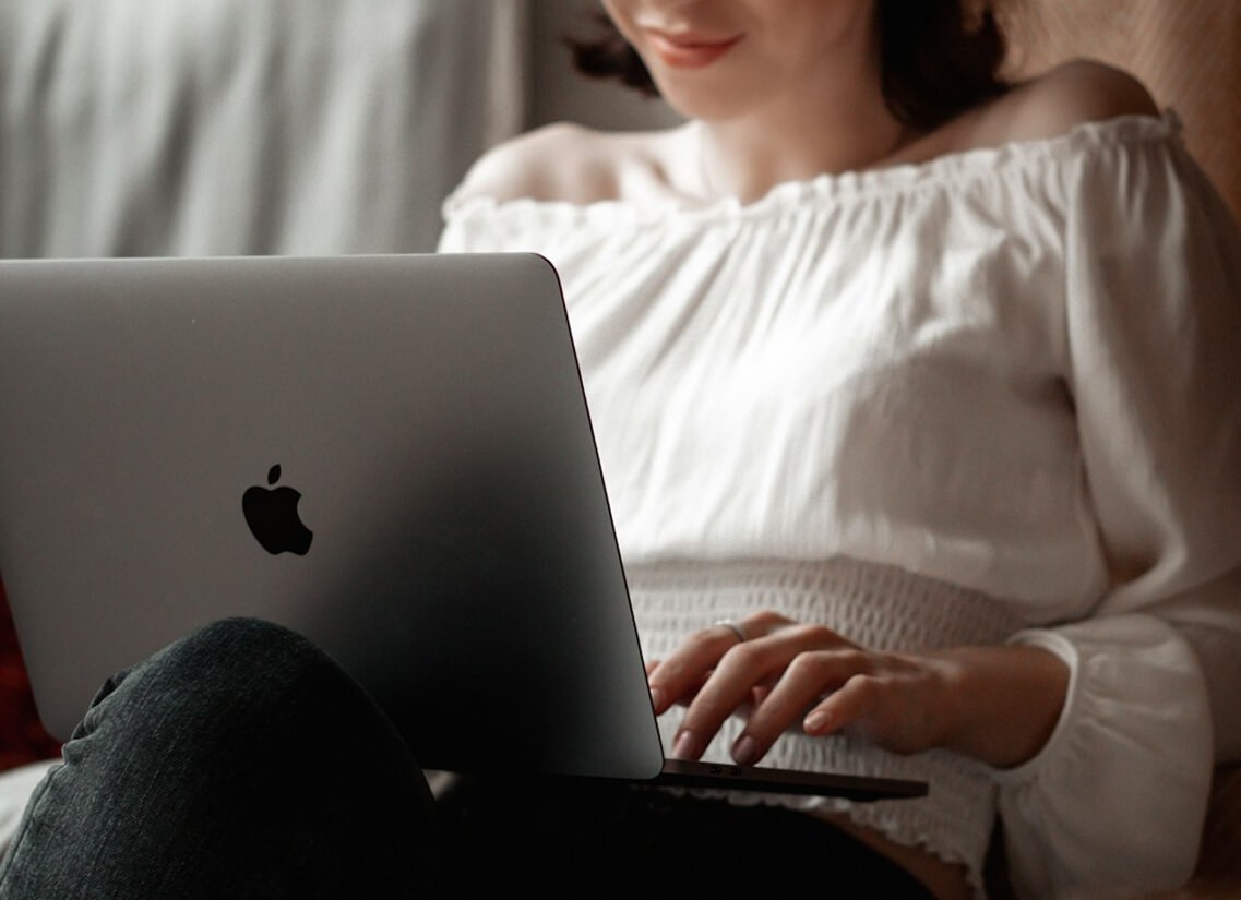 Person in a white off-shoulder top using a MacBook laptop, with text overlay 'What's new building.' and the inspologo in the top corner.